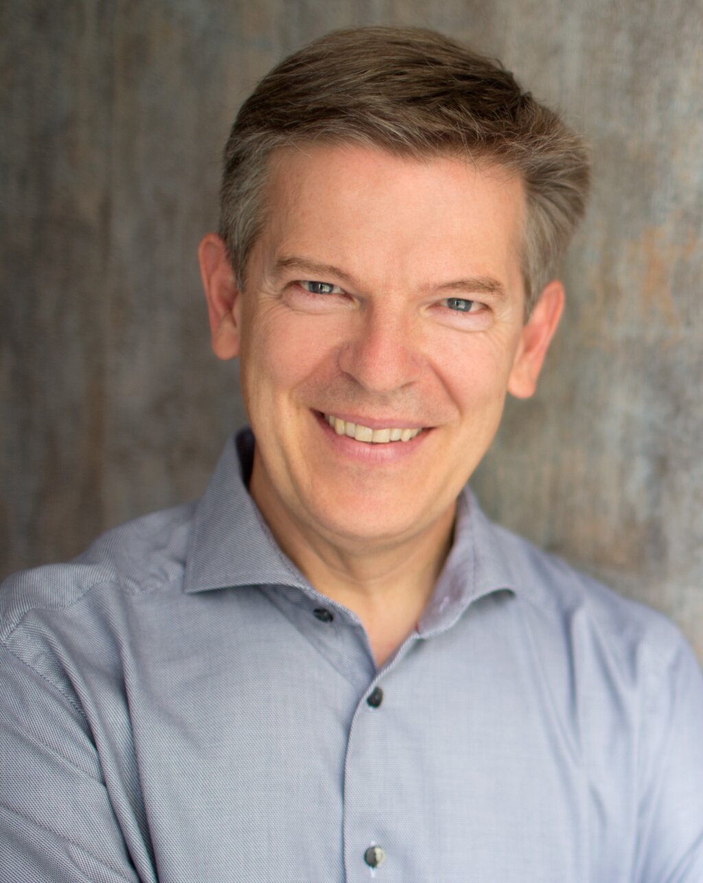 Man in shirt smiling to the camera.